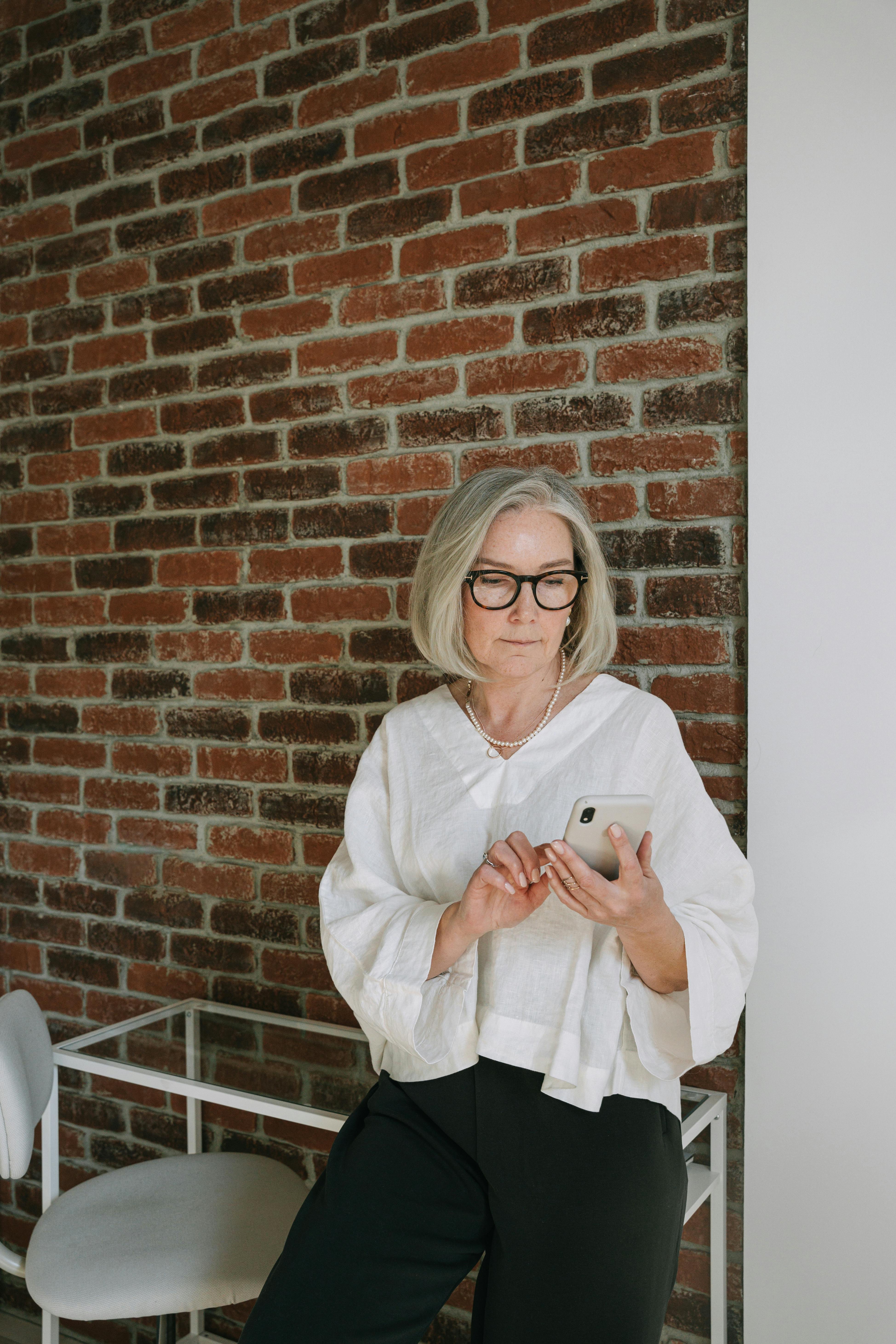 An elegant older woman confidently using her smartphone