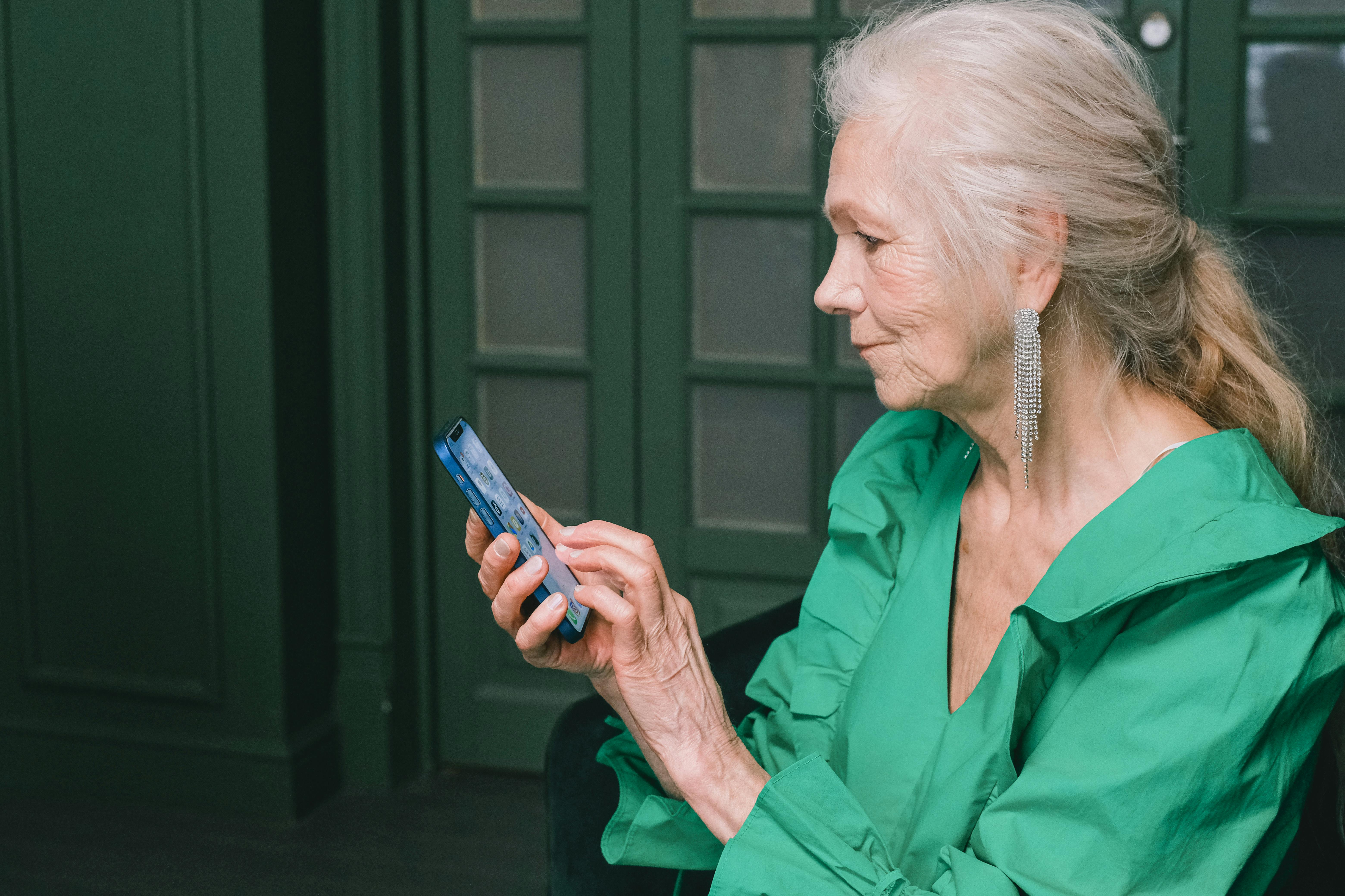 A stylish older woman confidently using her smartphone