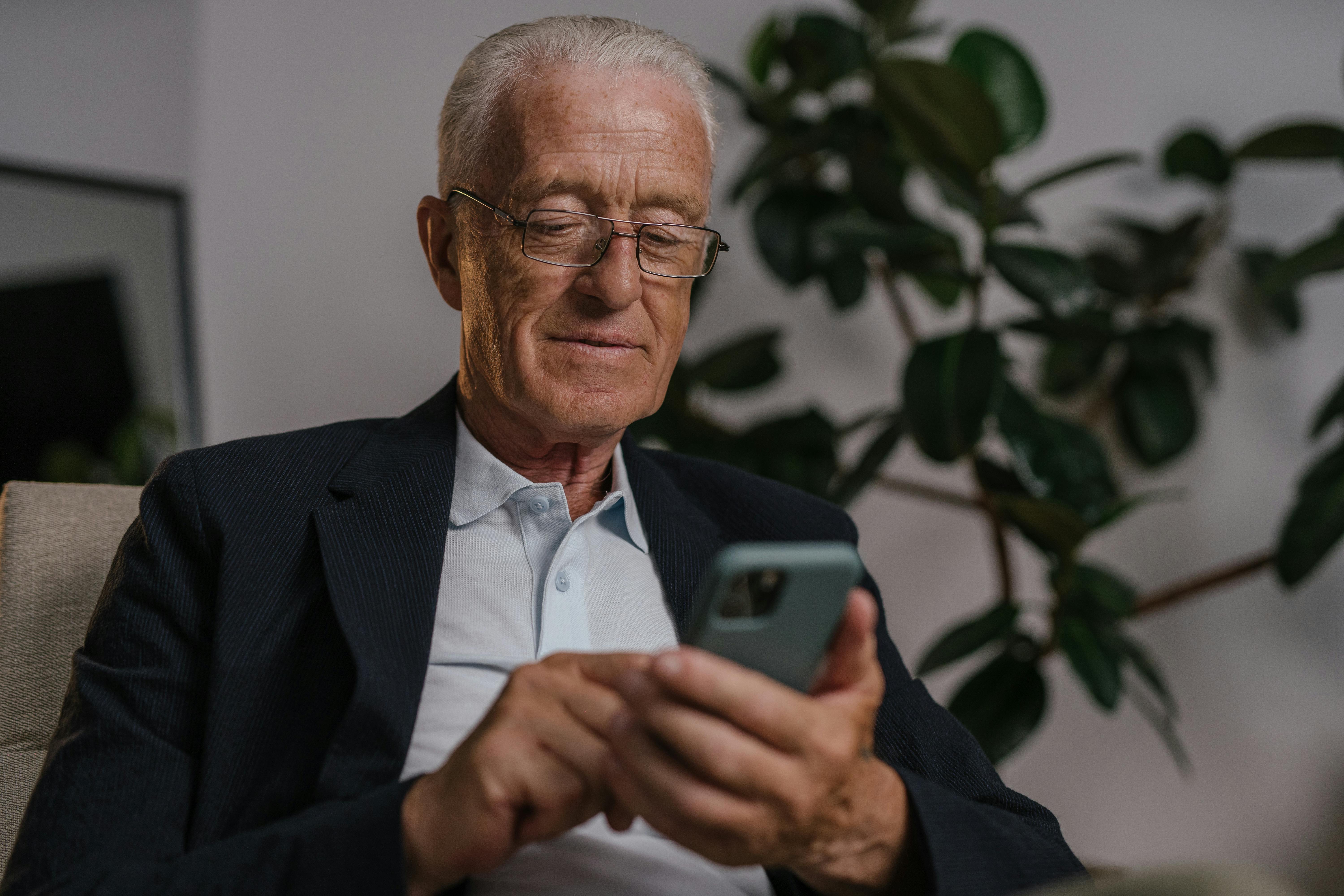 A confident older gentleman using his smartphone