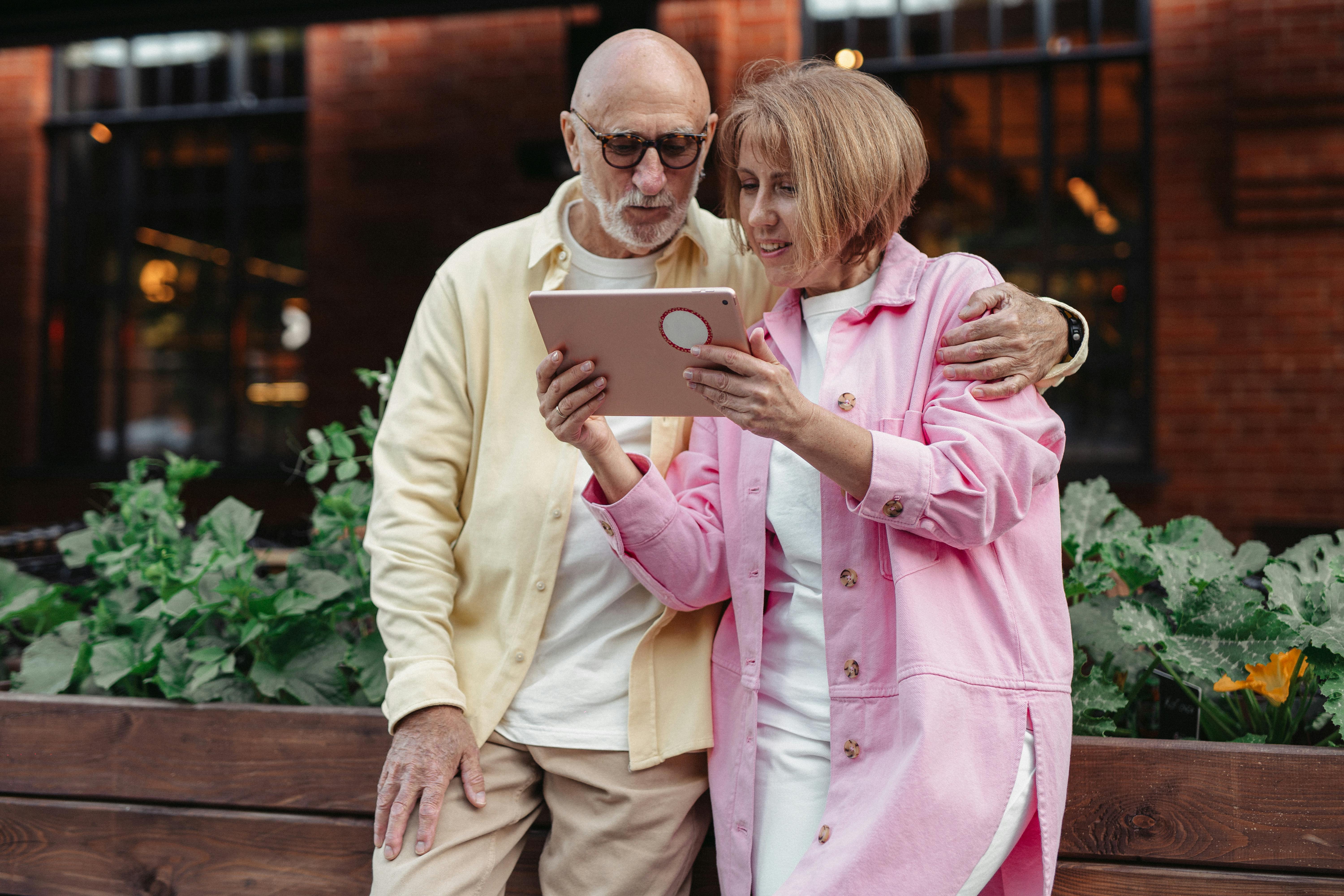 A couple exploring their tablet together outdoors